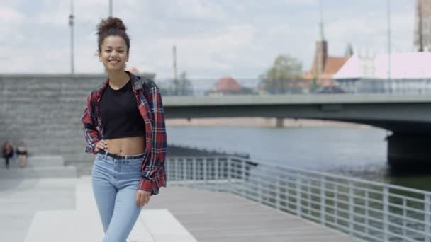 Portrait of a young african american woman wearing checkered shirt, outdoors. — Stock Video