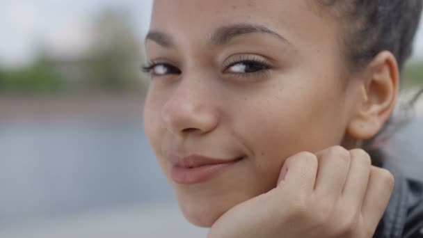 Close up van een jonge Afro-Amerikaanse vrouw die lacht naar een camera. — Stockvideo