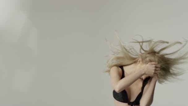 Porträtt av en vacker sexig blond kvinna klädd i svart underkläder. — Stockvideo