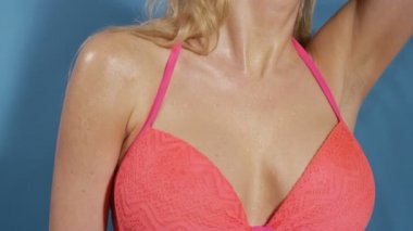 Güzel genç seksi kadın mavi arka plan üzerinde bikinili poz.