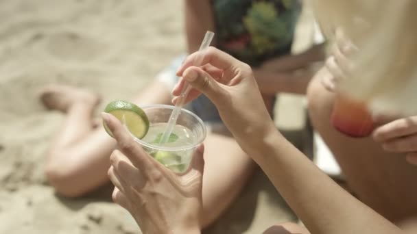 Zwei Mädchen sitzen am Strand und amüsieren sich. — Stockvideo
