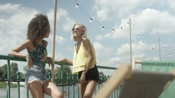 Duas belas meninas desfrutando de verão perto do lago . — Vídeo de Stock