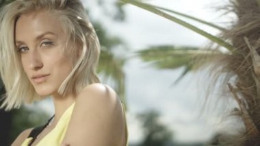 Tropik sahilde poz seksi sarışın kız.