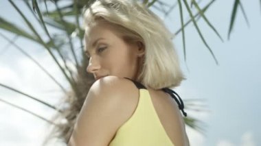 Tropik sahilde poz seksi sarışın kız.