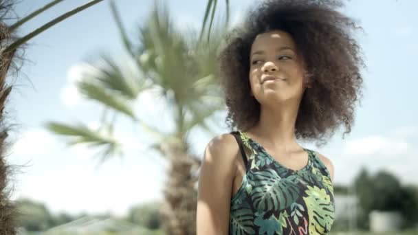 Retrato de una hermosa adolescente afroamericana en la playa tropical sonriendo a una cámara . — Vídeo de stock