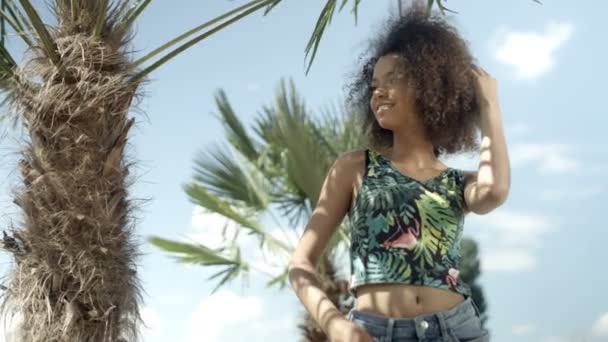 Portret van mooie Afro Amerikaanse tienermeisje op tropisch strand lacht om een camera. — Stockvideo