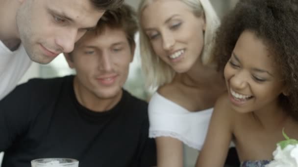 Groupe d'amis regarder des photos sur téléphone mobile et rire .