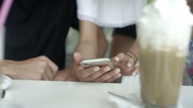 Cep telefonu kullaranarak Restoran bir masada oturan karışık yarış insanlar.
