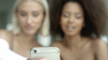 İki çok etnik kız cep telefonuyla fotoğraf çekmek.