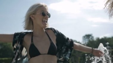 İki genç mutlu hippi kız eğleniyor, açık güneş gözlüğü.