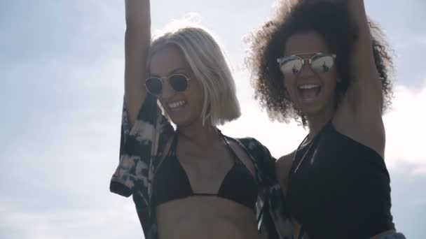 Two young happy hipster girls in sunglasses having fun, outdoor. — Stock Video