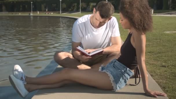 Romantic couple relaxing by the water in summer park. — Stock Video