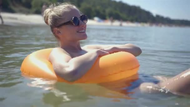 Menina bonita flutua em um anel de boia salva-vidas no mar, em algum lugar na Polônia . — Vídeo de Stock