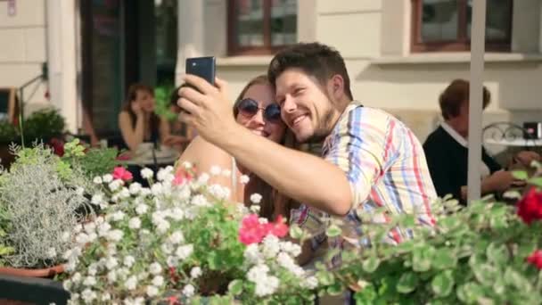 Young couple taking a selfie together on the cafe terrace on sunny day