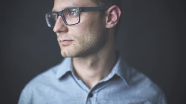 Young attractive man looking at camera having a serious look isolated on black background — Stock Video