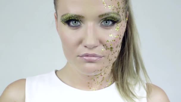 Sexy Kaukasische vrouw met kunst gouden make-up poseren in studio. — Stockvideo