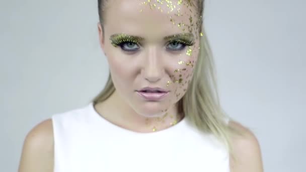 Sexy Kaukasische vrouw met kunst gouden make-up poseren in studio. — Stockvideo