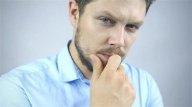genç işadamı portresi düşüncelerinde gri arka plan üzerinde kaybettim.