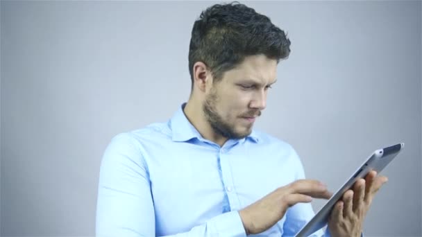 Empresário usando um computador tablet - isolado sobre um fundo cinza — Vídeo de Stock