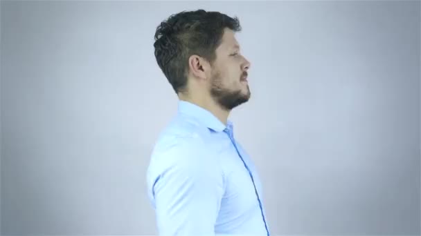 Succesvolle jonge man over grijze achtergrond in studio — Stockvideo