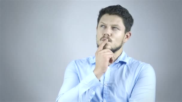 Genç işadamı portresi düşüncelerinde gri arka plan üzerinde kaybettim. — Stok video