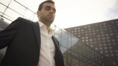 telefonunu seyir ve bina dışında bekleyen iş adamı