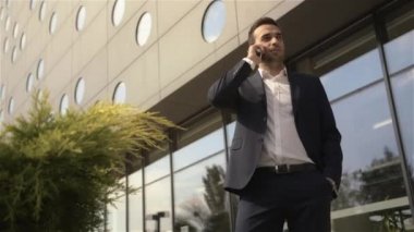 telefon için binanın önünde duran işadamı
