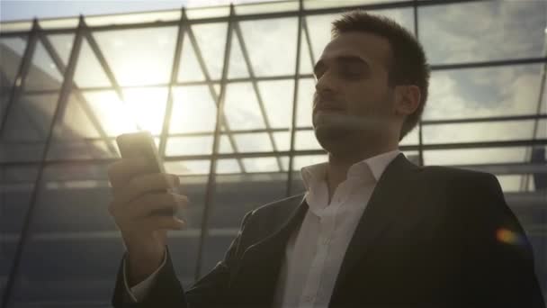 Businessman standing in front of building with telephone — Stock Video