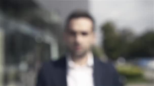 Portrait of an attractive businessman standing in front of modern building — Stock Video