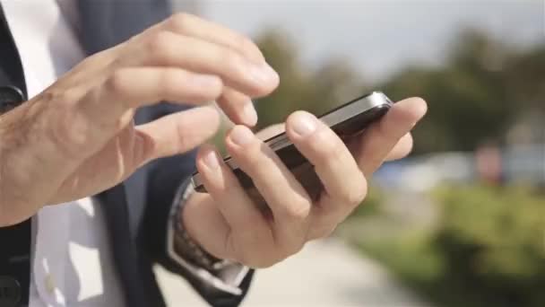 Primer plano de un hombre que utiliza el teléfono inteligente móvil al aire libre — Vídeos de Stock