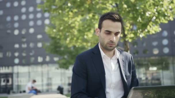 Fiatal, jóképű üzletember beszélő-ra mozgatható telefon-ban a város — Stock videók