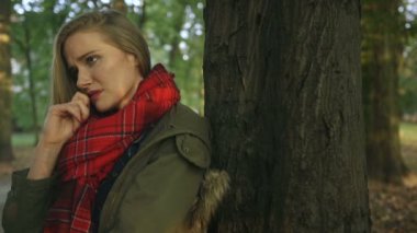 Sonbahar parkta üzgün genç güzel kız.