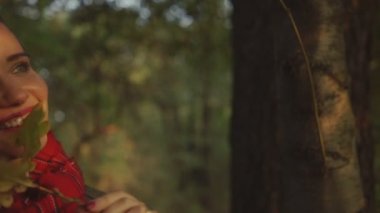 Sonbahar parkta gülümseyen genç sarışın kadın.