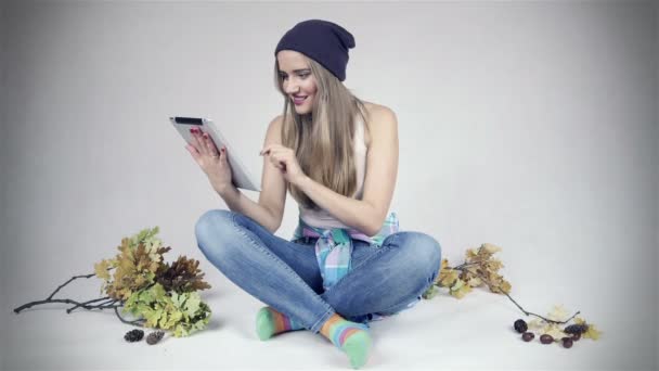 Mujer joven feliz usando tableta digital sobre fondo blanco — Vídeo de stock