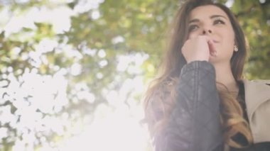 Sonbahar parkta gülümseyen düşünceli şık kadın.