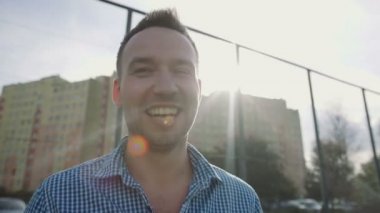 Bir modern çit duvar karşı açık gülümseyen yakışıklı adam.