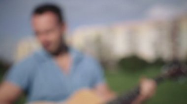 Gitar, şehir arka plan ile yakışıklı genç.