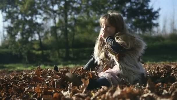 Kleines Mädchen spielt draußen im Herbstpark. — Stockvideo