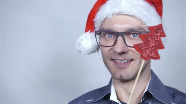 Feliz hombre de negocios con sombrero de santa sonriendo sobre fondo gris . — Vídeos de Stock