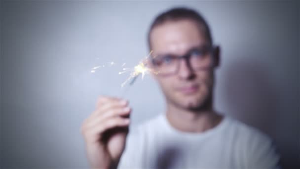 Happy new year celebrating man holding sparkles in studio. — Stock Video