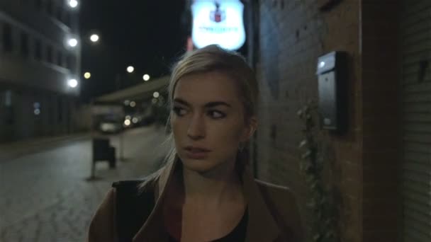 Jeune femme marchant dans la rue la nuit. — Video