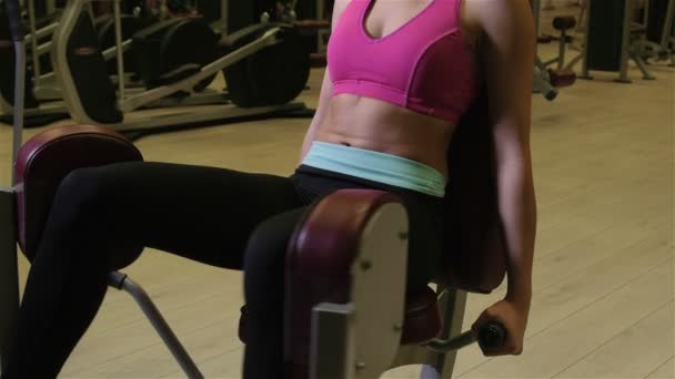 Mujer joven haciendo ejercicios de piernas en una máquina en el gimnasio . — Vídeos de Stock