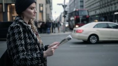 Genç güzel kadın bir harita ile şehrin sokaklarında seyahat.