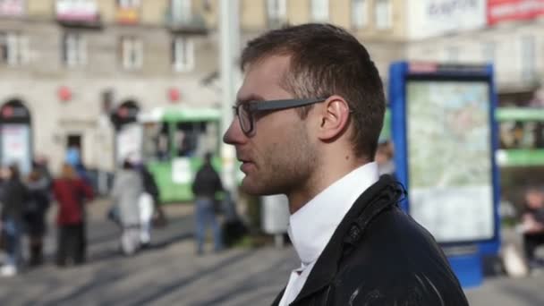 Joven hombre guapo mirando alrededor en la calle de la ciudad, orientación perdida . — Vídeos de Stock