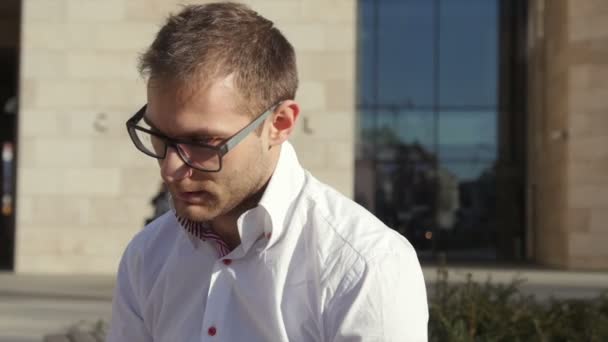 Gelukkig jonge zakenman praten over de telefoon zit achter zijn Bureau. — Stockvideo