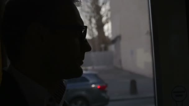 Close up of handsome young man traveling by tram in town. — Stock Video