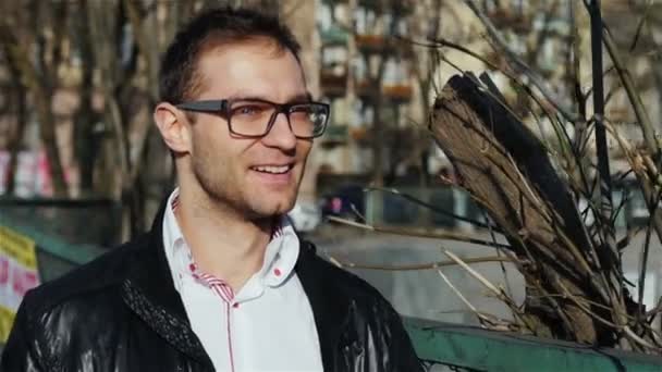 Porträtt av ung man bär glasögon promenader i stadens gator. — Stockvideo