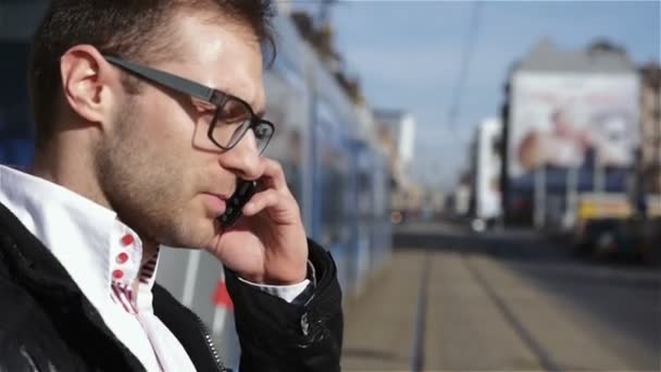 Un tânăr chipeş mergând şi vorbind la telefon, mişcarea lentă . — Videoclip de stoc