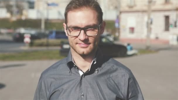 Portrait of young man wearing eye glasses walking in the city streets. — Stock Video