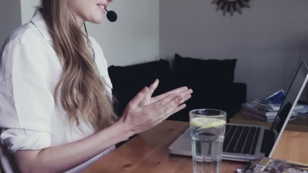 Женщина в наушниках разговаривает по скайпу с друзьями . — стоковое видео